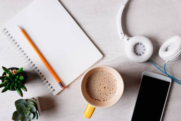 Overhead view of smartphone and accessories while drinking coffee
