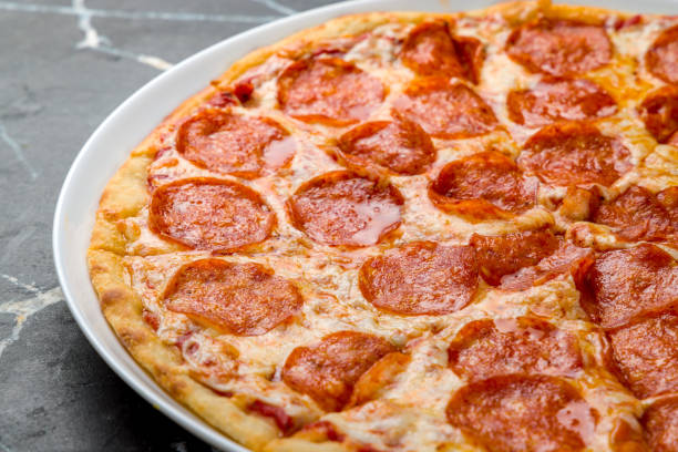 istock Pepperoni pizza on dark marble table close up 1363357325