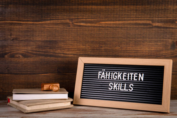 istock SKILLS. Text in English and German. Stack of books on the table 1363358462