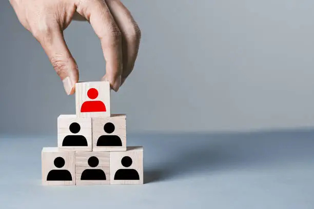 Gray background with wooden blocks of people silhouettes