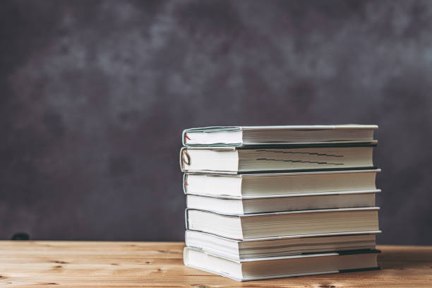 istock Gray background with stacked books on the desk 1363361136
