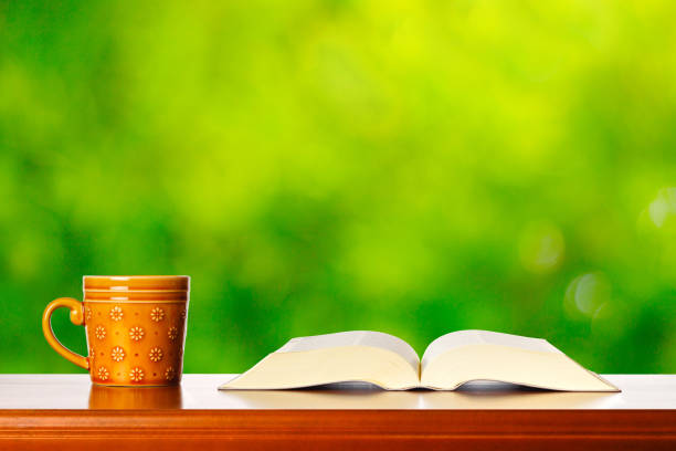 Brown mug and reading and green blur background