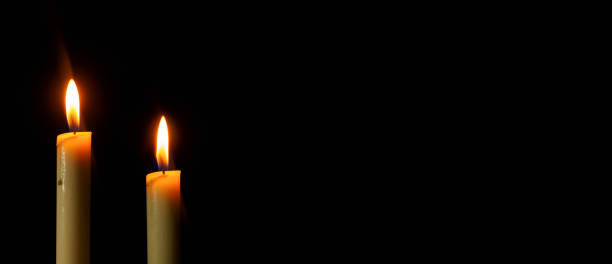 istock Two Candlelight burning brightly in the black background, blank and wide background for copy space. 1363379119