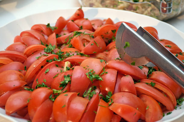 Image of dish with sliced, seasoned, healthy and vegetarian tomato salad for buffet