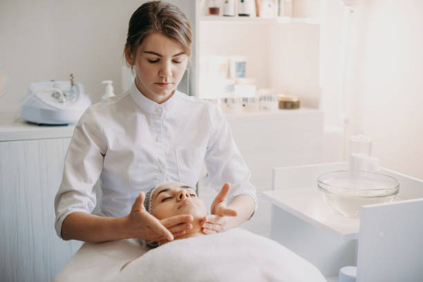 美容スパサロンでスパマッサージトリートメントを受ける女性。顔の美しさの処置。美容。 - massaging beautician beauty treatment facial massage ストックフォトと画像