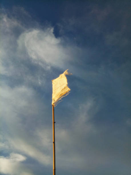 waving white flag against the blue sky background.