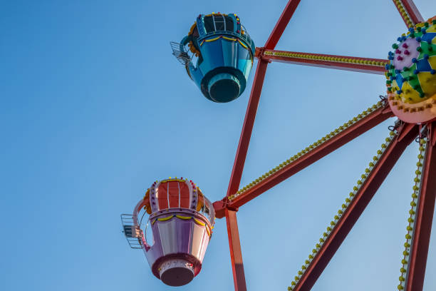 istock Ferris wheel in an amusement park against a blue sky. 1363381629