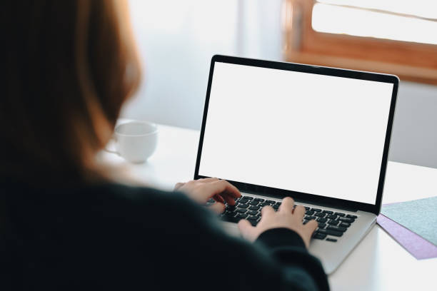 istock View over shoulder businesswoman using laptop computer at her office desk. 1363382461