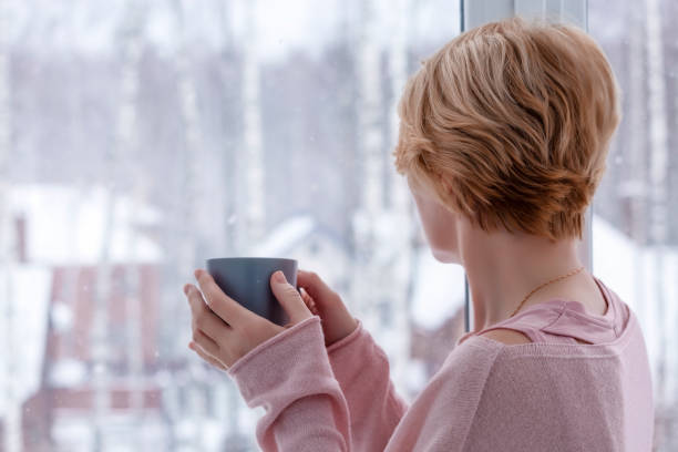 istock A woman drinks tea looking out the window 1363383276