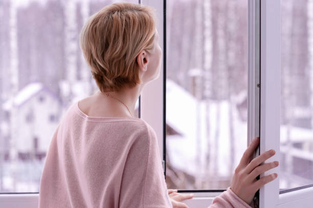 istock A woman looking out the window in winter 1363383277
