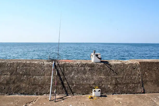 Japanese traditional fishing tackle style set on the quay on a summer hot day, photograph taken form behind.