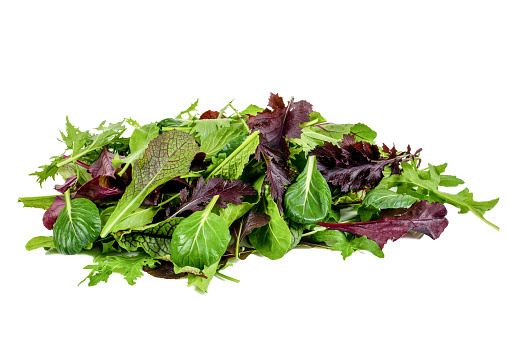 Mixed fresh mediterranean greens on isolated white background. Mediterranean salad ingredients