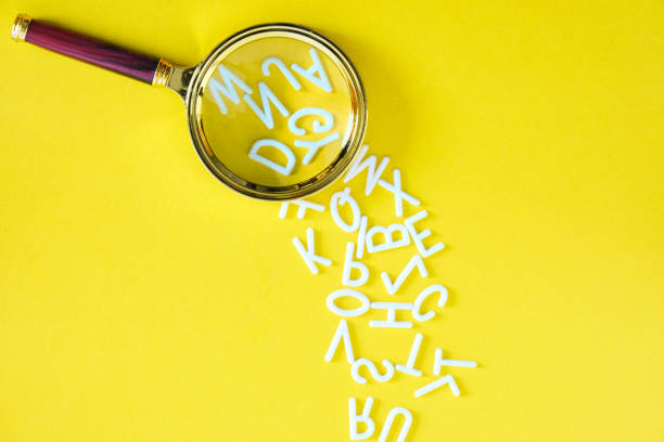 istock Letters English alphabet fallout magnifying glass, concept of knowledge and learning, on yellow background. 1363399714