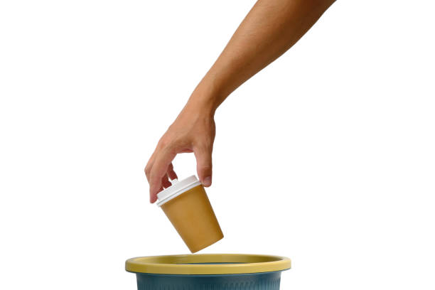 istock Hand on white background throws disposable cup of takeaway coffee into trash.Recycling and ecology. 1363399728