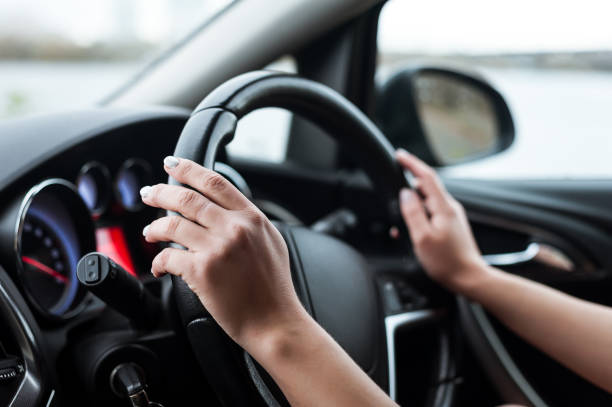 les mains des femmes sur le volant, à l’intérieur de la voiture. - vehicle interior indoors window chair photos et images de collection