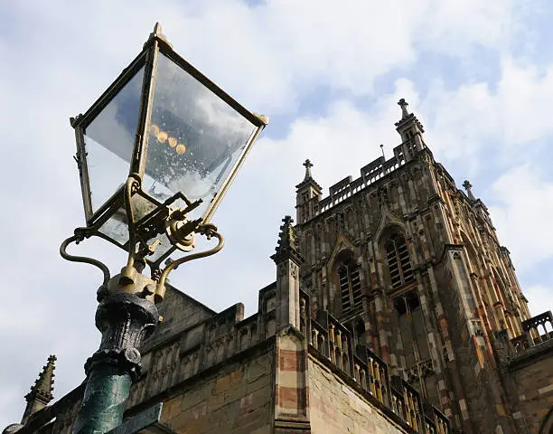 Low angle view of one of the gaslights in Great Malvern Priory churchyard, the inspiration for the lantern in C.S.Lewis's 'Narnia' novels. Church tower in background.
