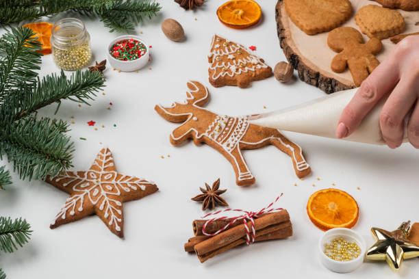 istock Female hands paint Christmas gingerbread cookies. 1363408035