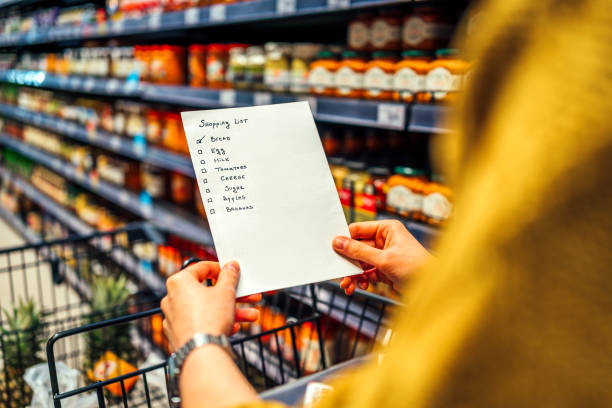 Woman with shopping list in grocery store Shopping list in hand of woman in grocery store shopping list stock pictures, royalty-free photos & images