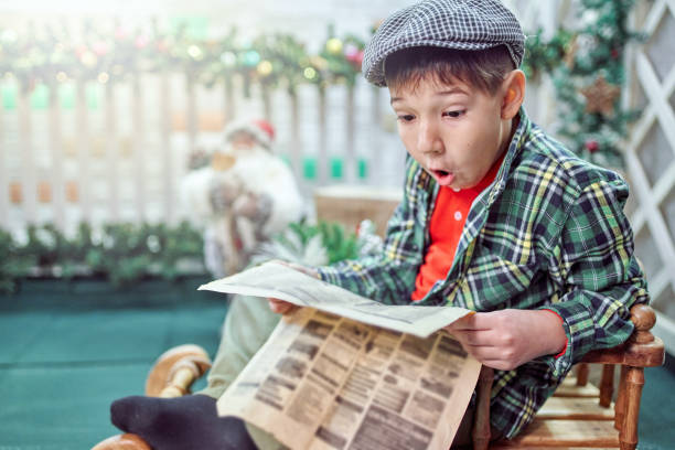 Funny Boy Is Reading Paper In Sled At Christmas Evening