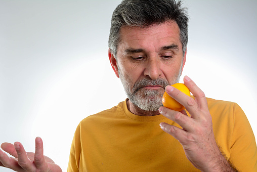 Anosmia or smell blindness, loss of the ability to smell, one of the possible symptoms of covid-19, infectious disease caused by corona virus. Man Trying to Sense Smell of a Lemon