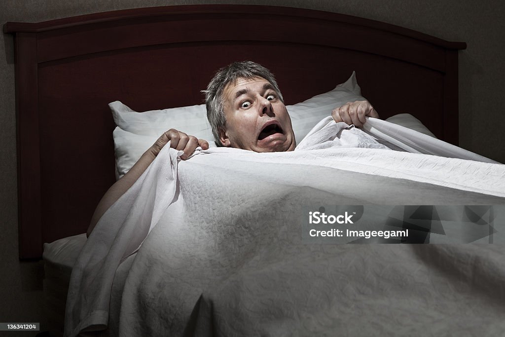 Man startled awake by intruder Home invasion by burglar concept Fear Stock Photo