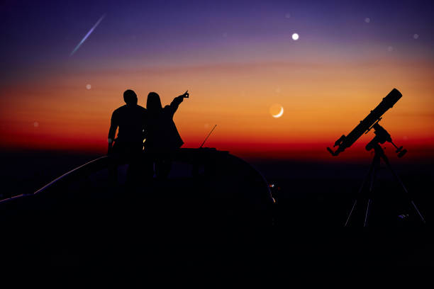 istock Couple stargazing together with a astronomical telescope. 1363413488