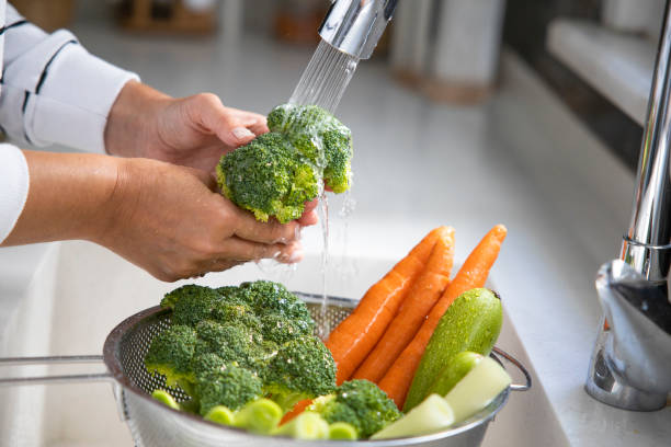 istock Woman washing vegetables on kitchen counter 1363417083