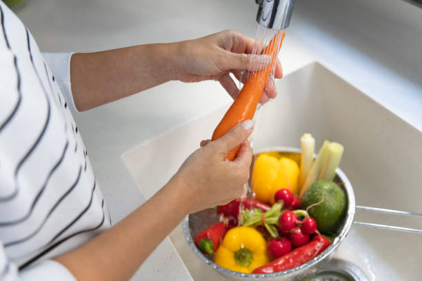 istock Woman washing vegetables on kitchen counter 1363417185