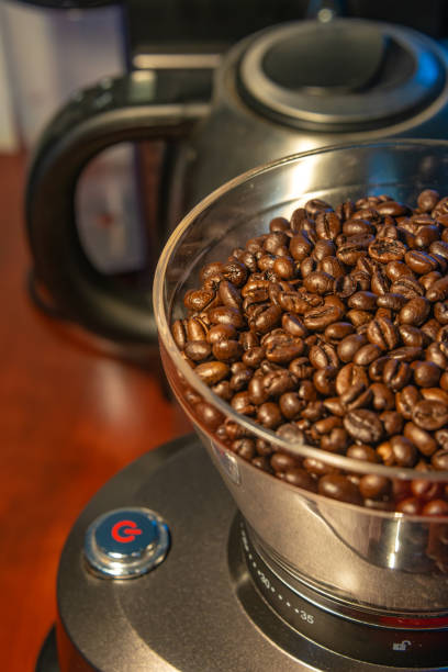 istock Coffee grinder with red start button, filled with fresh coffee beans, closeup, details 1363419312