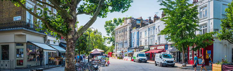 Shoppers and tourists enjoying the independent stores, restaurants and cafes in a attractive street in Primrose Hill, central London, UK.