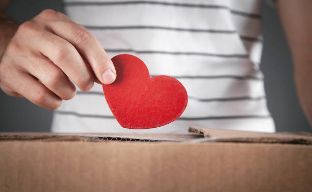 istock Male hand putting red heart in box. 1363422277