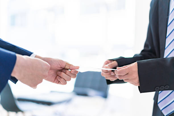 istock Businessman exchanges business cards with a smile 1363423568