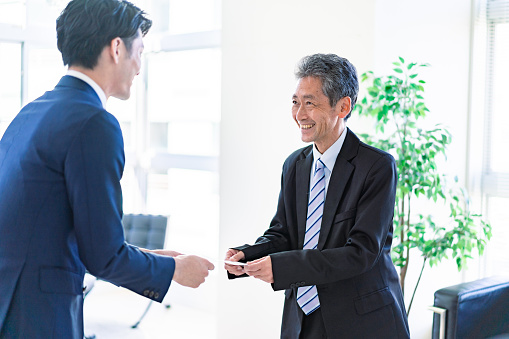 Businessman exchanges business cards with a smile