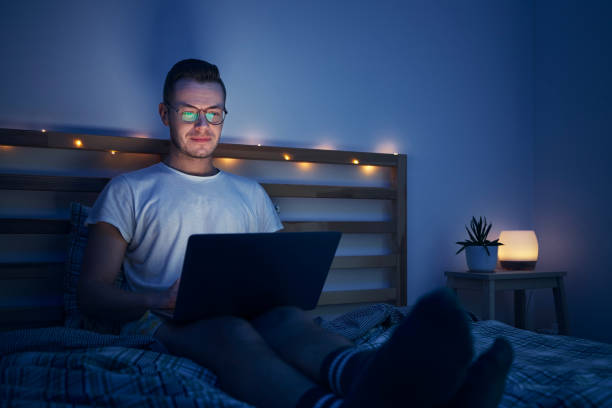 istock Man in bed watching laptop at night 1363424862