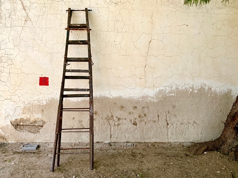 an old wooden ladder leans against a wall in Namibia