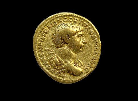 Gold Roman aureus coin of  Roman emperor Trajan AD 98-117 cut out and isolated on a black  background, stock photo image