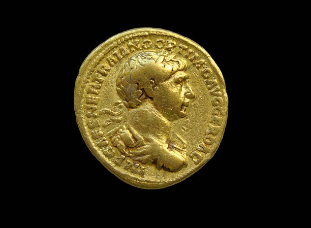 Gold Roman aureus coin of  Roman emperor Trajan Gold Roman aureus coin of  Roman emperor Trajan AD 98-117 cut out and isolated on a black  background, stock photo image ancient rome photos stock pictures, royalty-free photos & images