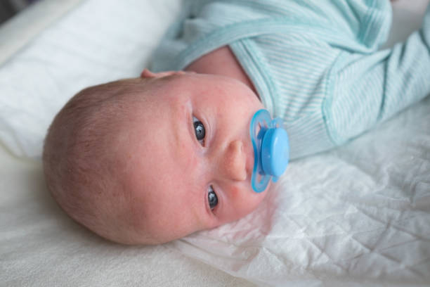 Cute baby girl with a pacifier in her mouth stock photo