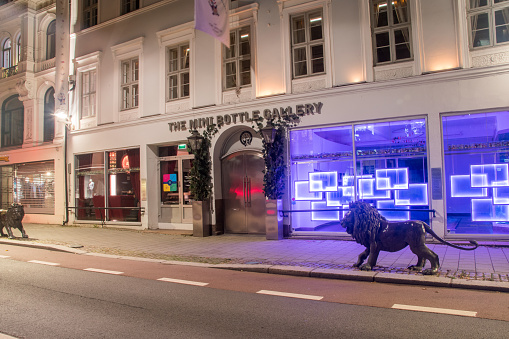 Oslo, Norway - September 24, 2021: The mini bottle gallery at night. Gallery with miniature bottles.
