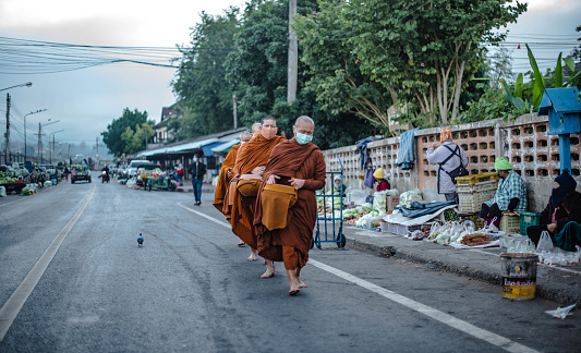 Monks coming out for alms rounds must wear masks to prevent infection with COVID-19. in Mae Hong Son Province, Thailand