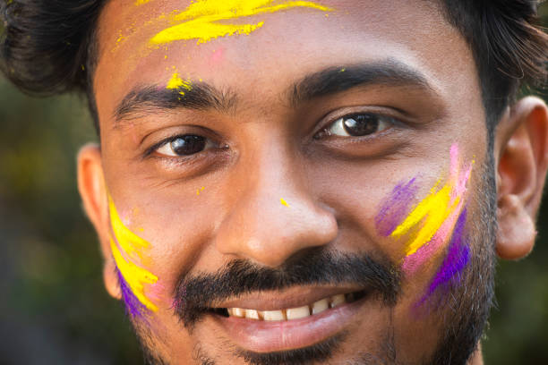 インドの西ベンガル州のホーリー・フェスティバルで、色付きの染料で覆われた若いインド人男性の目をクローズアップしてください。 - hinduism outdoors horizontal close up ストックフォトと画像