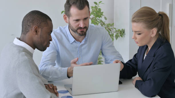 istock Business People with Laptop Dicsussing Project in Office 1363437516