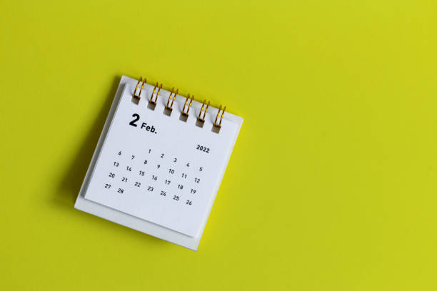 istock Desktop calendar for February 2022 on a yellow background. 1363438393