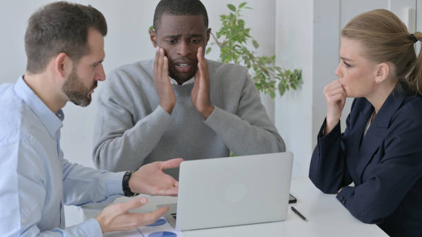 istock Disappointed Business People having Loss while using Laptop in Office 1363438491