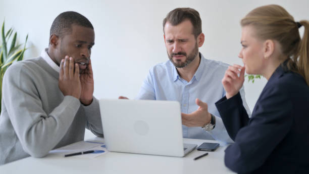 istock Disappointed Business People having Loss while using Laptop in Office 1363438529