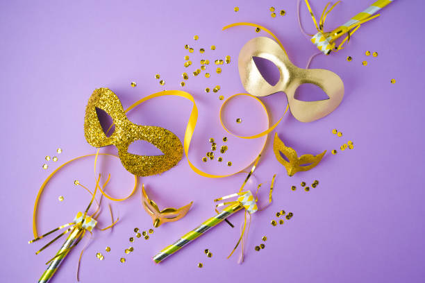 Carnival or mardi gras creative layout with golden carnival mask on violet background. Flat lay composition