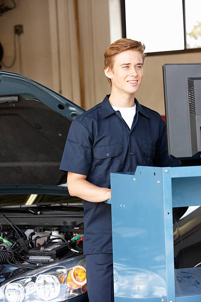 mechanik w pracy - trainee auto repair shop computer manual worker zdjęcia i obrazy z banku zdjęć