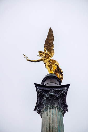 Statue of a golden angel called The Peace Angle Friedensengel in the center of the German city Munich which is the capital city in Bavaria