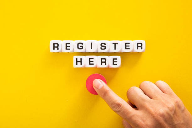istock Hand pushing button with Register Here word on yellow background 1363443481