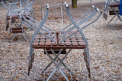 Tables and chairs in a part of a public park which normal is utilized as a beer garden but due to Covid-19 and winter is temporary closed in the center of the German city Munich which is the capital city in Bavaria